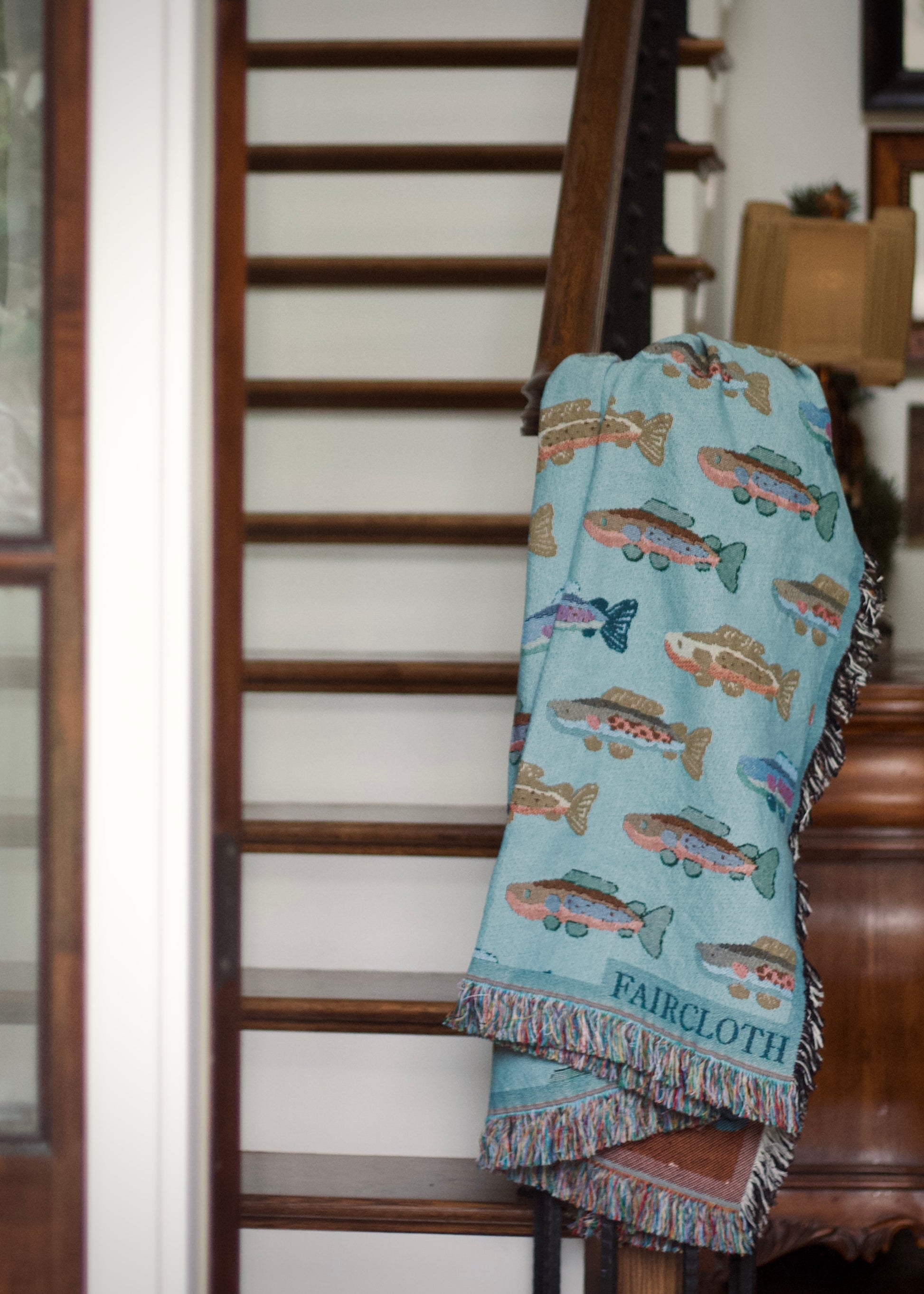 blue faircloth blanket with tiled colorful fish across it
